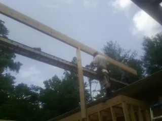 Carpenter setting a ridge beam over a new addition frame — Ice Dam Removal by Roofing Brothers in Trout Creek