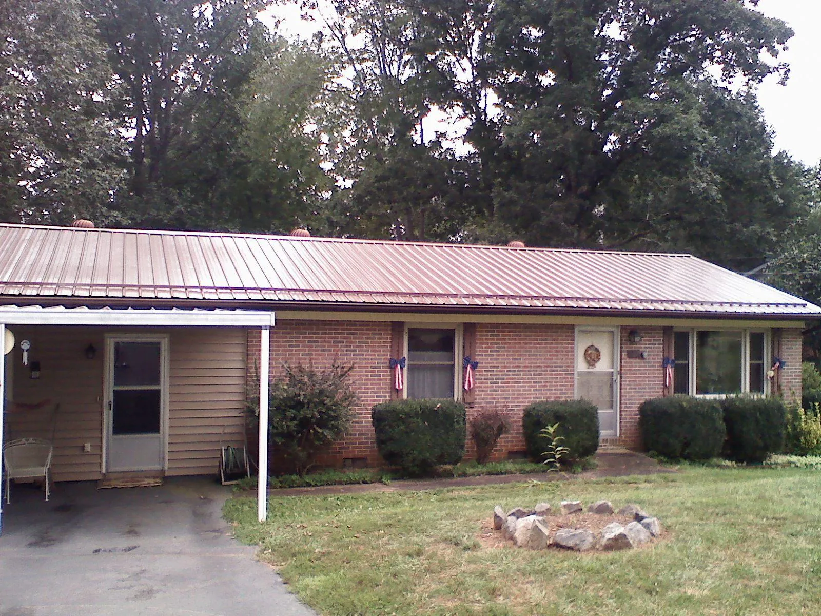 Bronze metal roof and carport on a brick ranch home — Roof Repair work by our crew in Trout Creek